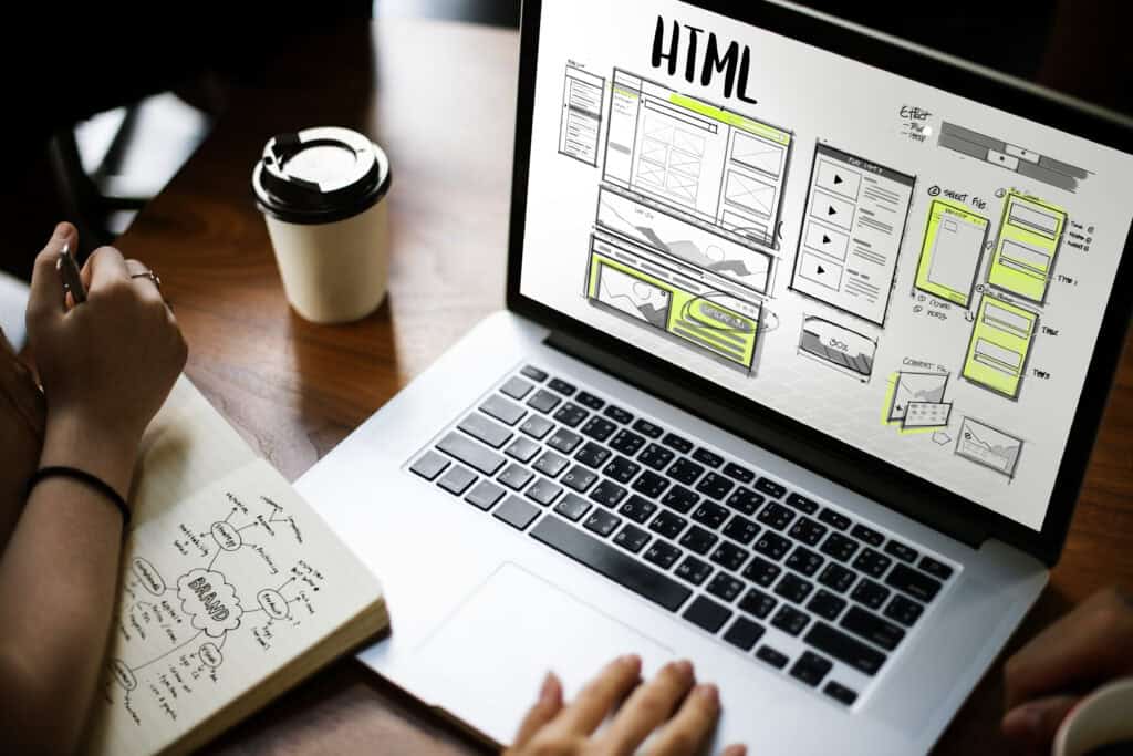 Esquisse de mise en page d’un site web à côté d’un ordinateur portable
