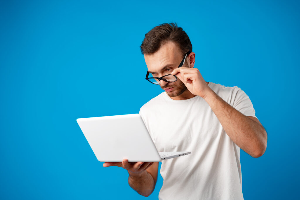 jeune homme utilisant son ordinateur portable sur fond bleu