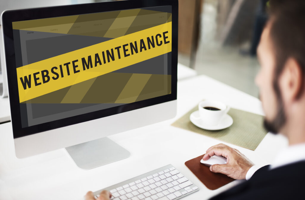 Écran affichant « Website maintenance » devant un développeur